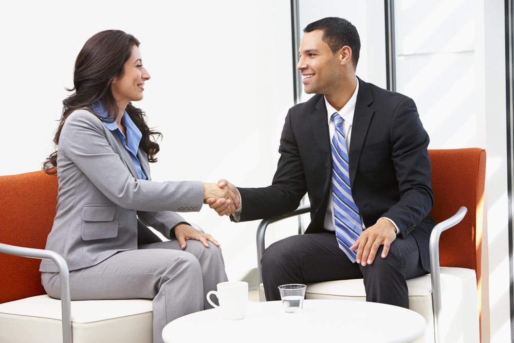A businessman and a businesswoman shake hands